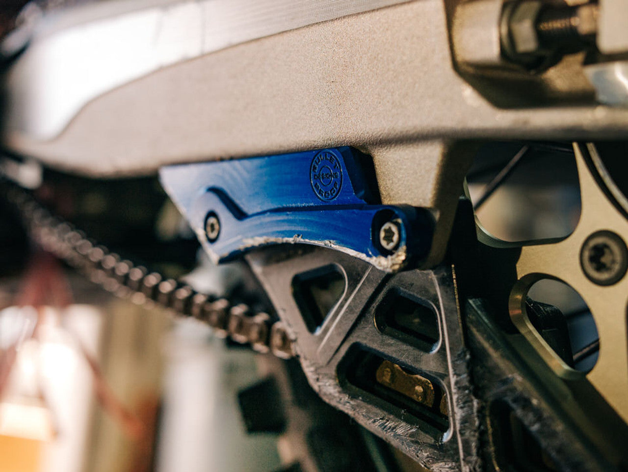 Bullet Proof Designs swingarm guard for KTM, Husqvarna, and GasGas dirt bikes protects chain guide tabs from rocks, roots, and trail damage