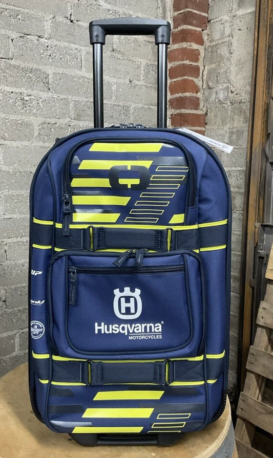 A navy blue and yellow striped Husqvarna brand suitcase with telescopic handle, top and side grab handles, and two external pockets.