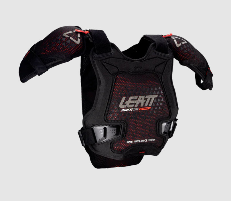 Black protective chest and shoulder pad with red accents on a gray background
