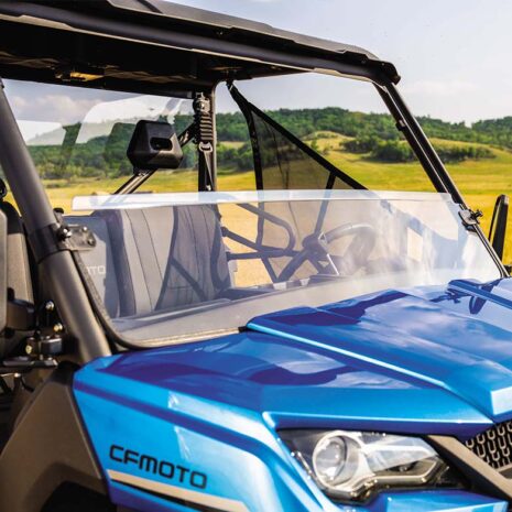 A clear half windshield made of polycarbonate installed on a blue CFMOTO UFORCE 1000 off-road vehicle.
